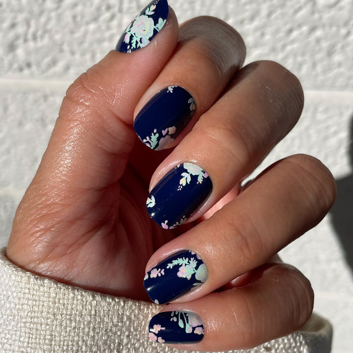 Hand with Micro Floral - Press-Ons | Extra Short | Squoval featuring pastel flowers on dark navy nails for fresh spring mani