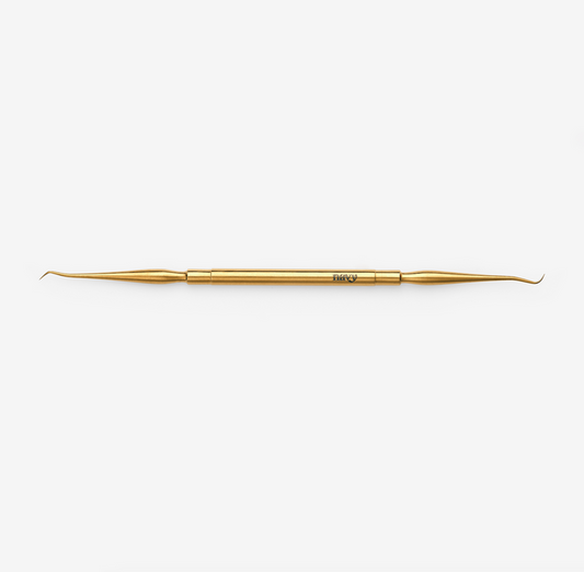A double-ended lash lifting tool, gold in color