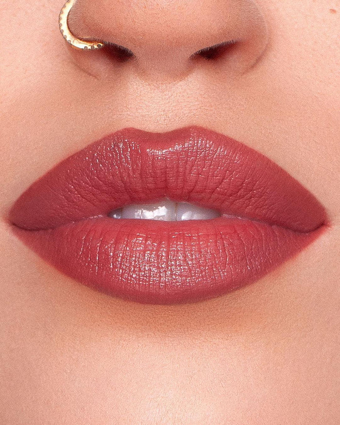 Woman applying KASH Devotion lipstick