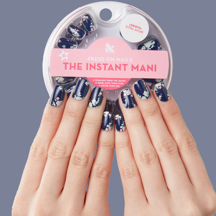 Hands wearing Micro Floral - Press-Ons | Extra Short | Squoval with floral design on dark navy base for spring mani