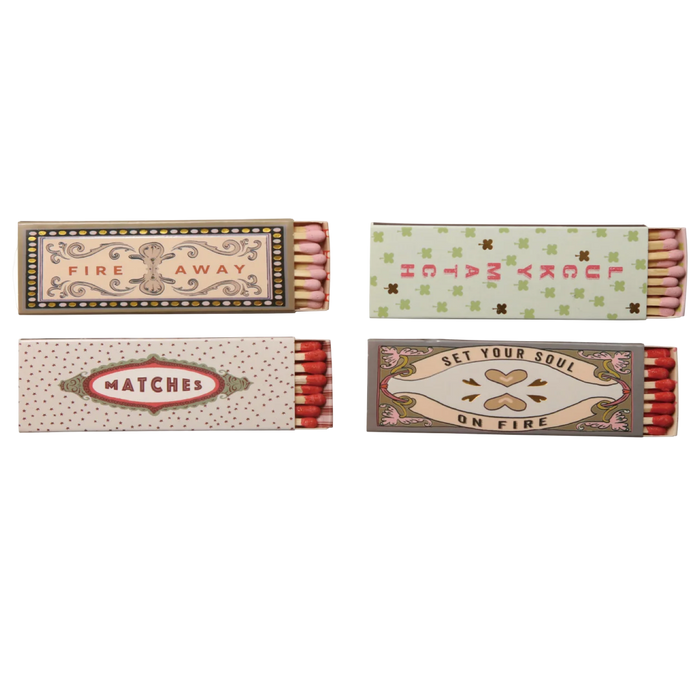Four matchboxes with decorative labels on a white background