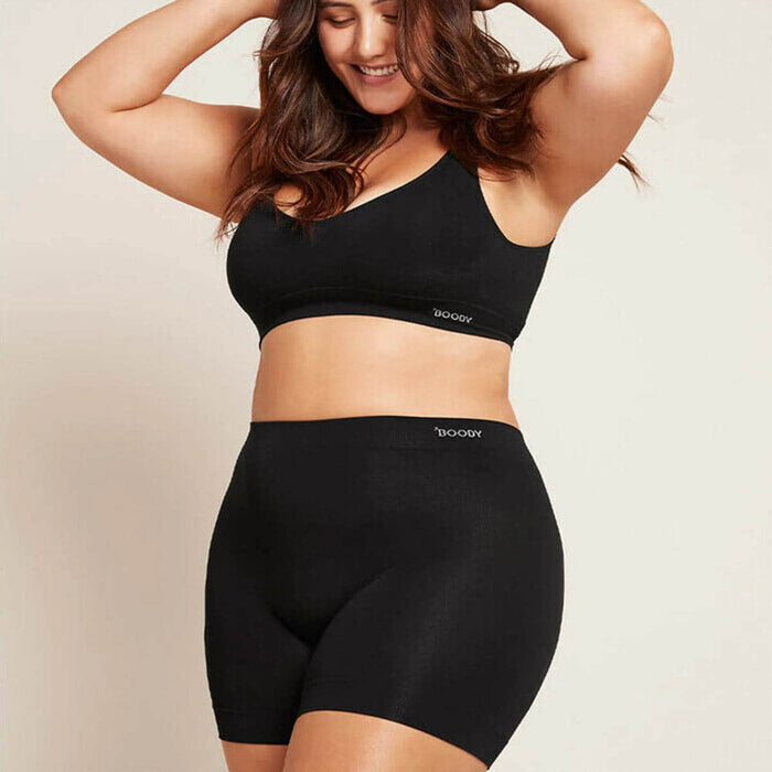 Model wearing Boody Smoothing Short in black with a matching crop bra.