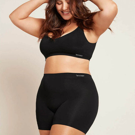 Model wearing Boody Smoothing Short in black with a matching crop bra.