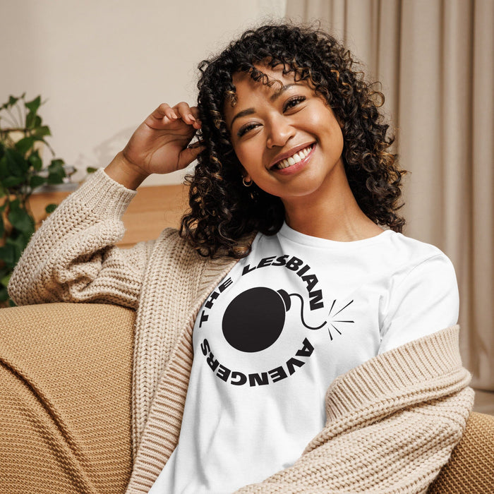 Woman wearing a white sweatshirt with a graphic design, sitting on a couch.