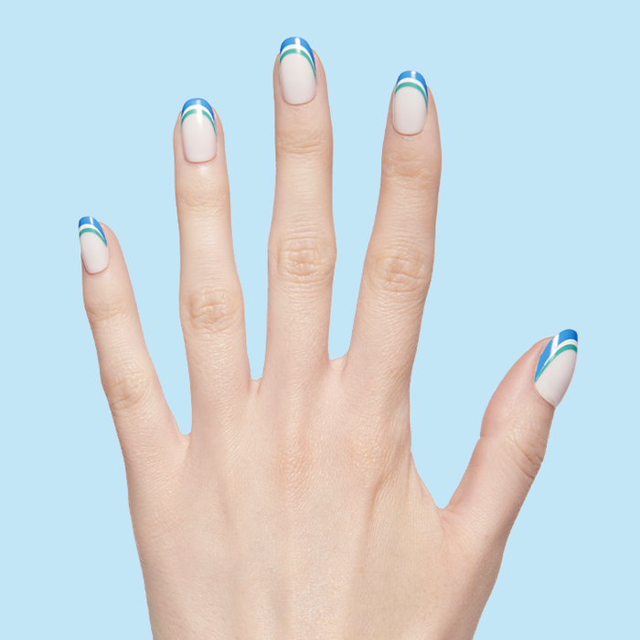 Hand displaying Triple French | Round | Short press-on manicure with blue and green triple stripe tips on pale base