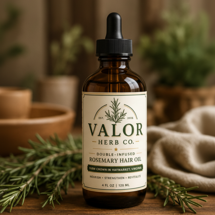 Bottle of Valor Herb Co. rosemary hair oil with herbs on a wooden surface